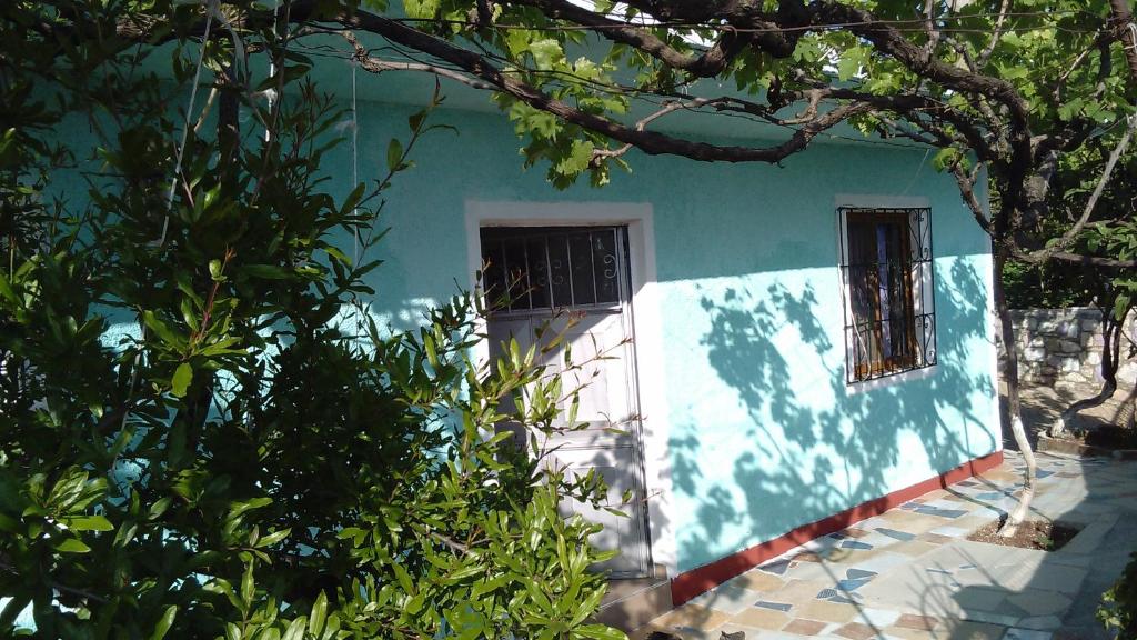 ein blau-weißes Haus mit zwei Fenstern in der Unterkunft Keno's Apartment in Sarandë