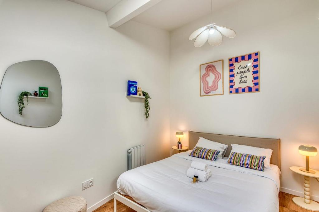 une chambre avec un lit et un miroir dans l'établissement Le Pastel - Cosy Appart - métro B - 1 à 4 personnes, à Oullins