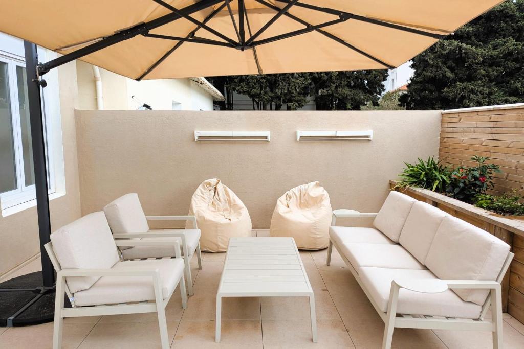 d'une terrasse avec un mobilier blanc et un parasol. dans l'établissement Penthouse with large terrace near beaches, à Toulon