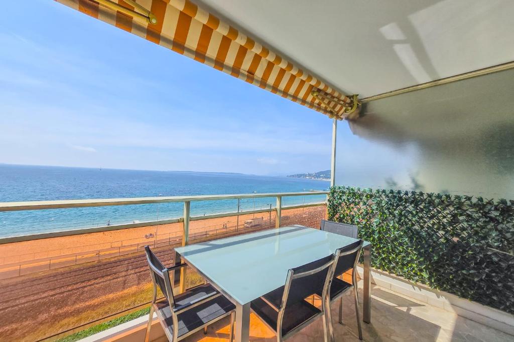 a table and chairs on a balcony with the ocean at Apartment 4 guests front of the sea in Antibes