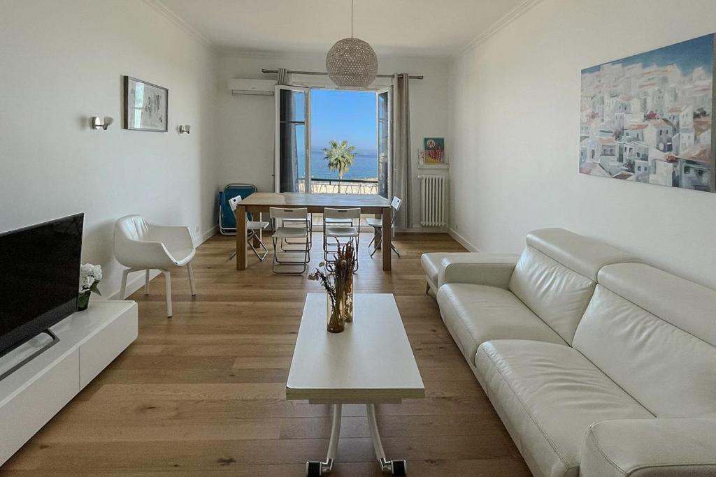 un salon avec un canapé et une table dans l'établissement Seafront Apartment for 6 Promenade des Anglais, à Nice