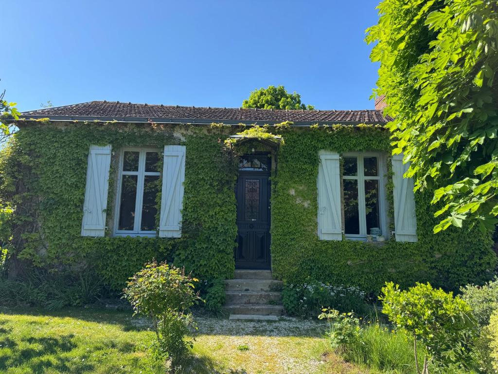 a house covered in ivy with a door at Cottage-Saint Laurent sur Sèvre in Saint-Laurent-sur-Sèvre