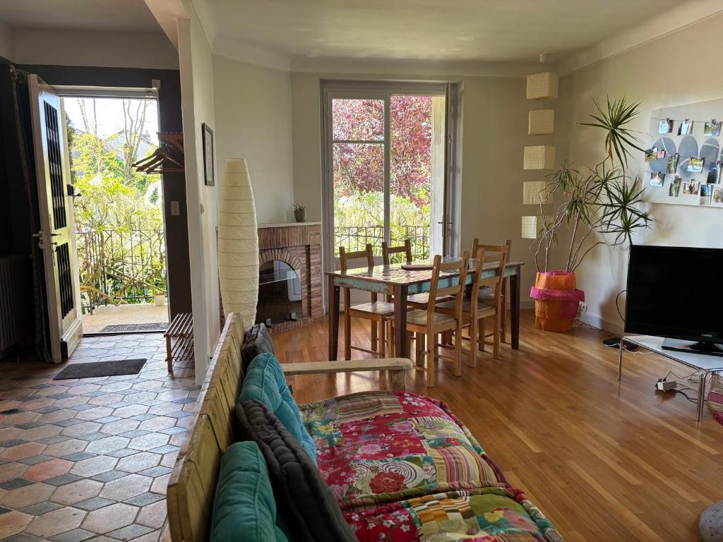 un salon avec un canapé et une table dans l'établissement Havre de paix cosy avec jardin proche du centre-ville de Poitiers, à Poitiers