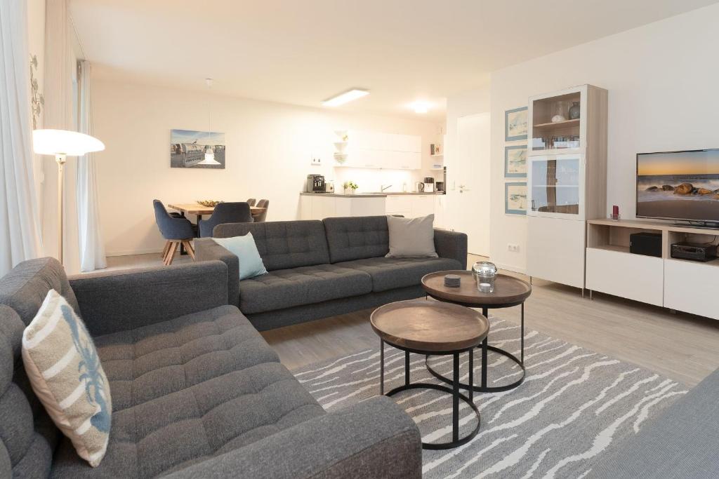 a living room with a couch and a table at Nien 2 Wildrose in Grömitz