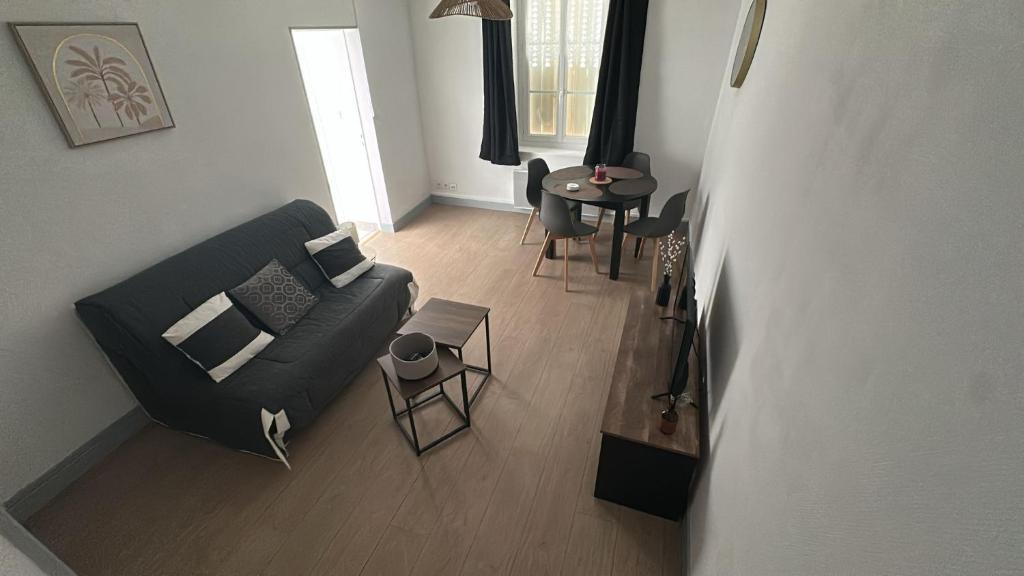 ChaulgnesにあるMaison cosy près du circuit Nevers Magny-Coursのソファとテーブルのあるリビングルーム