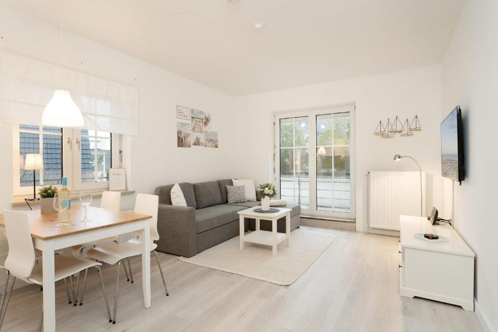 a white living room with a couch and a table at Ferienwohnung Jankar in Timmendorfer Strand