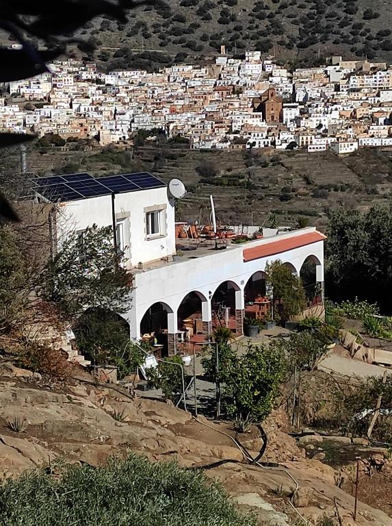 un edificio blanco en una colina con una ciudad en Casa Rural en Ohanes, 1 dormitorio - El Cortijo Escondido, La Rosa, en Ohanes