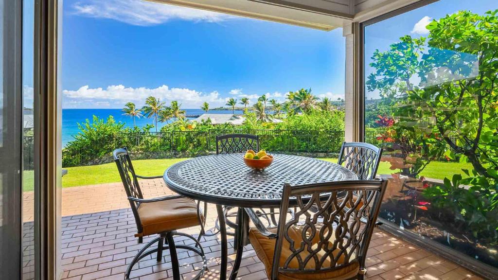 a table and chairs on a patio with a view of the ocean at Kapalua Bay Villa 18G2 in Kapalua