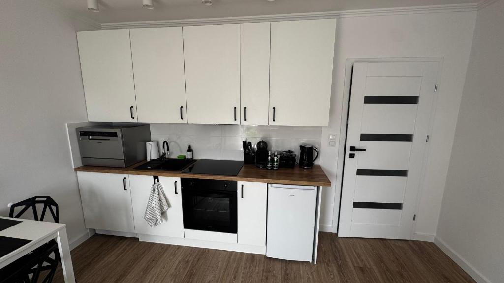 eine Küche mit weißen Schränken und einer Arbeitsplatte in der Unterkunft EG Apartments in Lublin