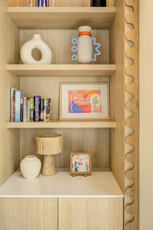a book shelf with a picture and a vase at Hôtel Gabriel in Menton
