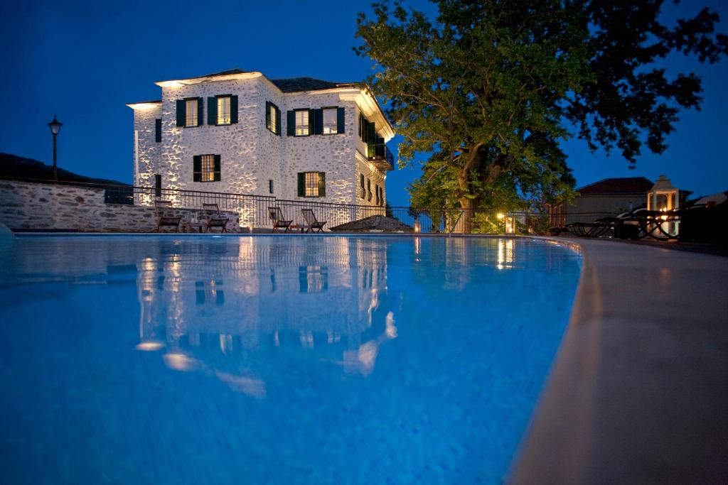 a large swimming pool in front of a building at Despotiko in Portariá