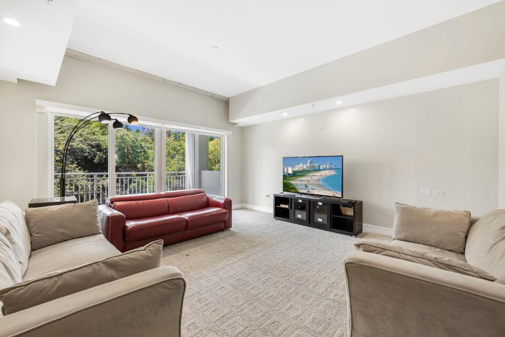 a living room with two couches and a television at Exclusive Doral Villa with Luxury Amenities in Miami