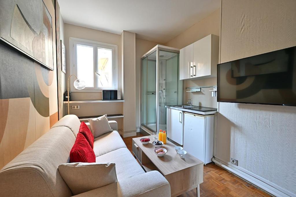 un salon avec un canapé et une table dans l'établissement Petit studio pratique Neuilly-sur-Seine - II, à Neuilly-sur-Seine
