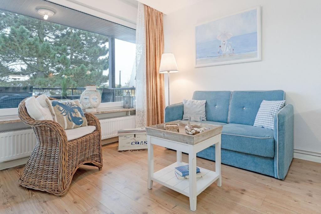 a living room with a blue couch and a table at Haus Baltic Traumfabrik in Scharbeutz