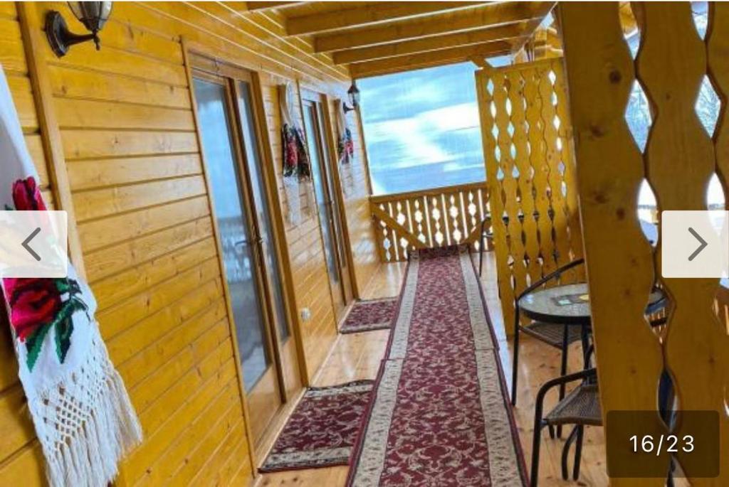 a room with a balcony with a table and chairs at Camere de închiriat Floarea Reginei in Vişeu de Sus
