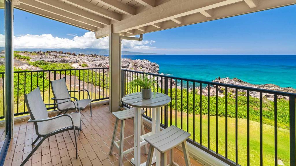 a balcony with a table and chairs and the ocean at Kapalua Bay Villa 30B2 in Kapalua