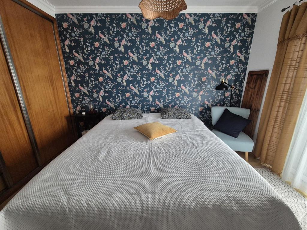 a bedroom with a bed with a floral wallpaper at Villa Alegria in Ericeira