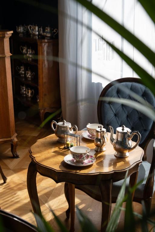 a wooden table with tea pots and plates on it at Palace Hotel in Viareggio
