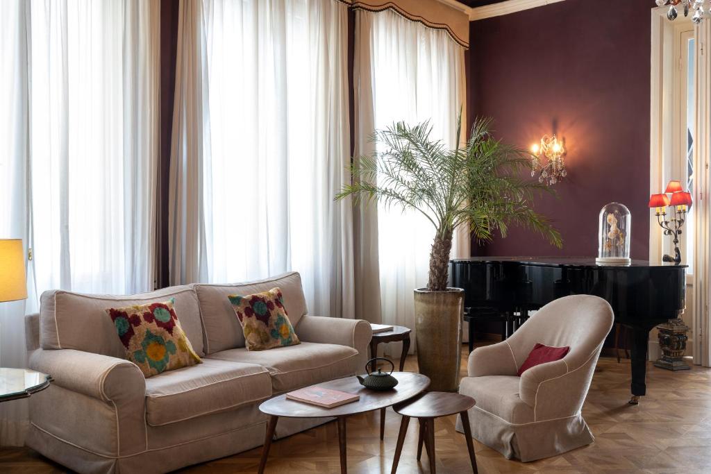 a living room with a couch and a piano at Palace Hotel in Viareggio