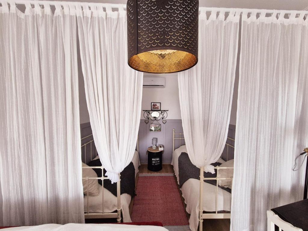 a room with two beds and white curtains at Villa Alegria in Ericeira