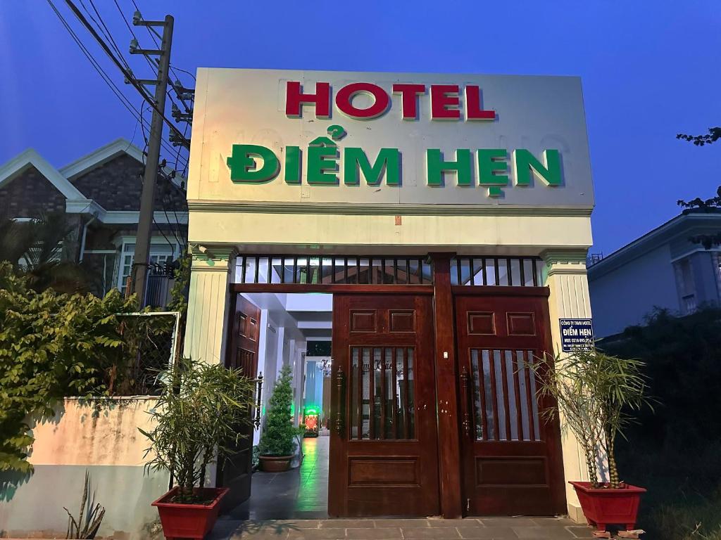 a hotel sign in front of a hotel dim hen at Khách Sạn Điểm Hẹn in Ho Chi Minh City