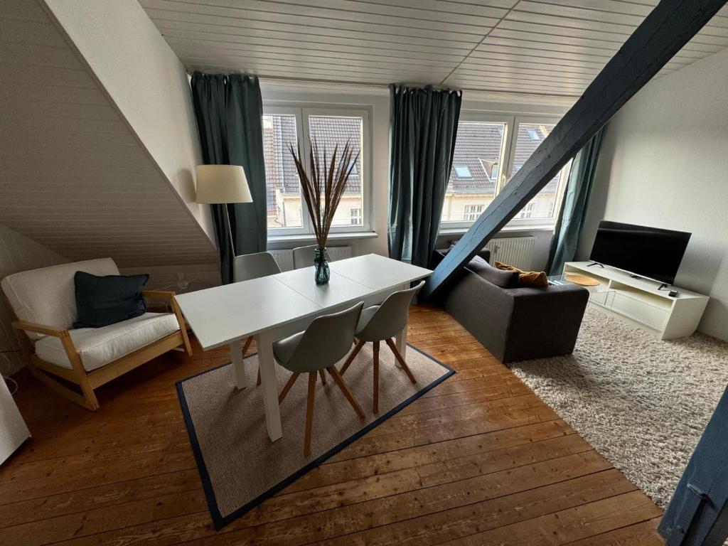 Una sala de estar con una mesa y sillas blancas. en Cosy & central flat near Düsseldorf center, en Düsseldorf