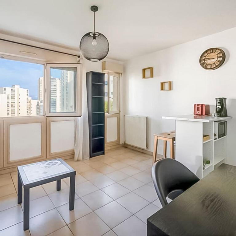 - un salon avec une table, un canapé et une fenêtre dans l'établissement Studio au Cœur d'Antigone, à Montpellier