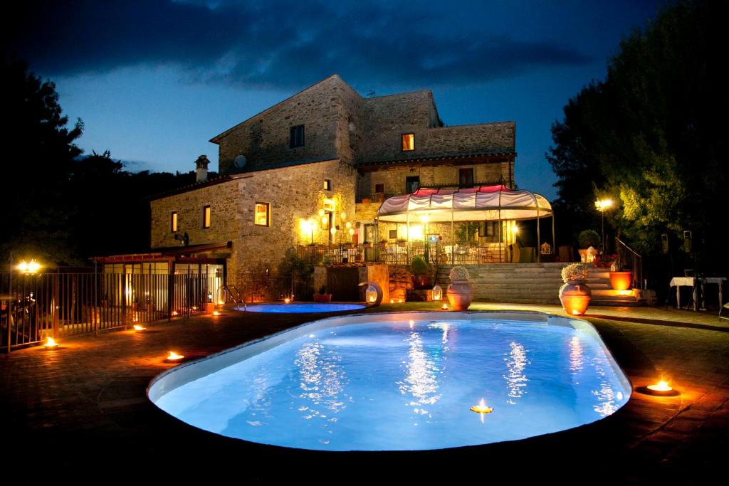 a large swimming pool in front of a building at night at Il Castelluccio Country Resort Restaurant & SPA in Barberino di Mugello