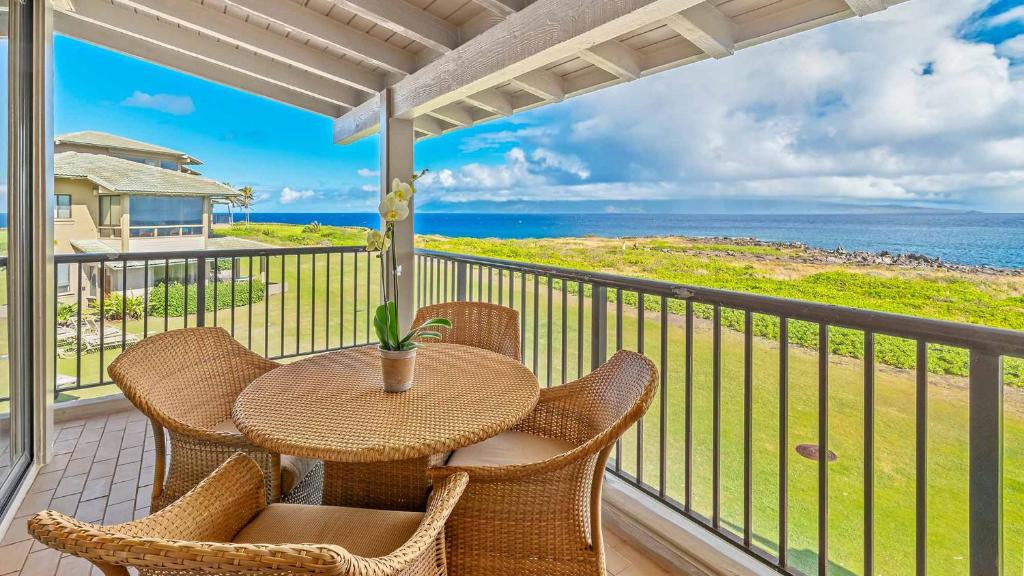 a table and chairs on a balcony with the ocean at Kapalua Bay Villa 35B2 in Kapalua