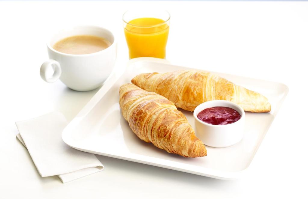 a plate with two croissants and a cup of coffee at Premiere Classe Salon De Provence in Salon-de-Provence