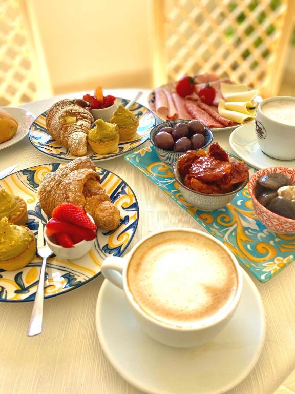 a table with plates of pastries and a cup of coffee at Hotel Sylesia in Letojanni