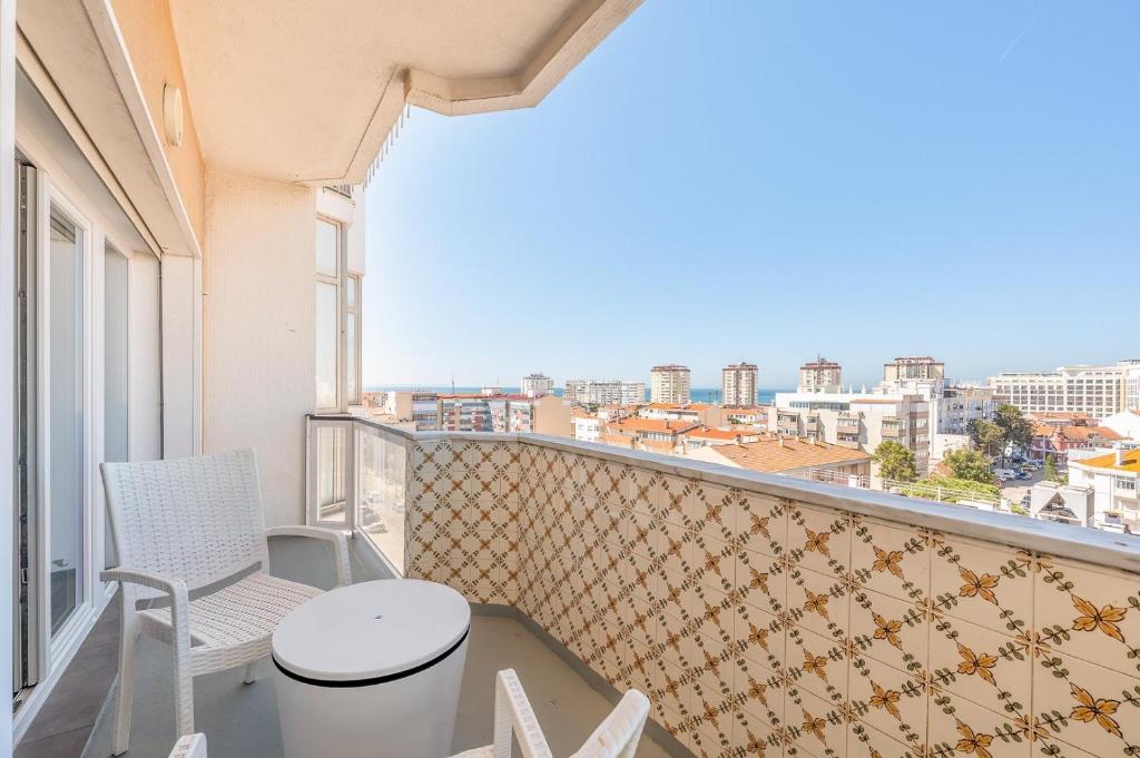 コスタ・ダ・カパリカにあるGuestReady - Seaview in Costa da Caparicaの景色を望むバルコニー(テーブル、椅子付)