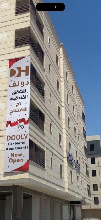 Un edificio con un cartel al costado. en Doolv Serviced Apartments, en Tabuk