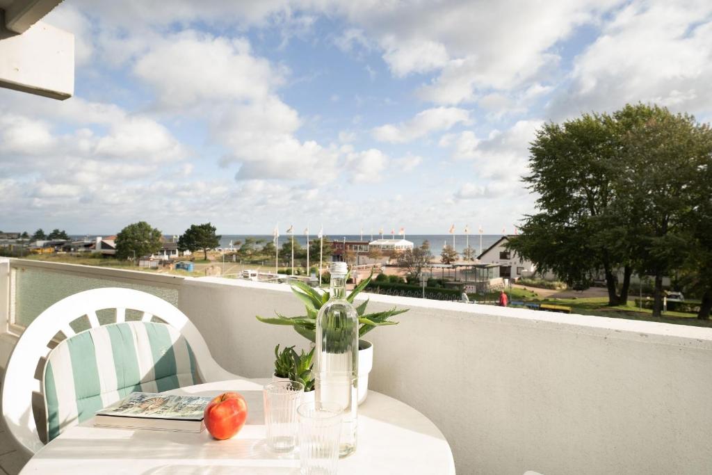 a table and chairs on a balcony with a view of the ocean at Haus Vier Jahreszeiten Wellenblick in Dahme
