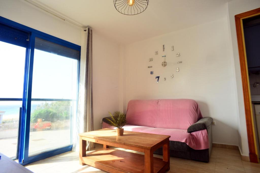 un salon avec un canapé et une horloge au mur dans l'établissement Livingtarifa Apartamento Blue II, à Tarifa