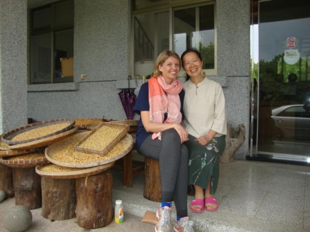 a man and woman sitting on a bench next to tables at Taroko Sialin Coffee Farm Homestay in Xiulin