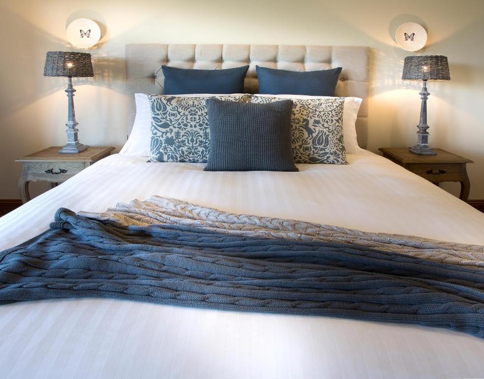 1 dormitorio con 1 cama blanca grande con almohadas azules en Drom Aluinn B & B en Acheron