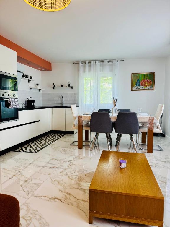 une cuisine et une salle à manger avec une table et des chaises dans l'établissement Trigone Premium 4 Stars, à Montpellier