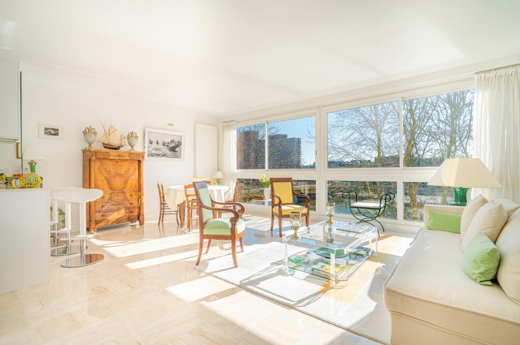 un salon avec un canapé, une table et des chaises dans l'établissement Lovely apartment with view, à Paris