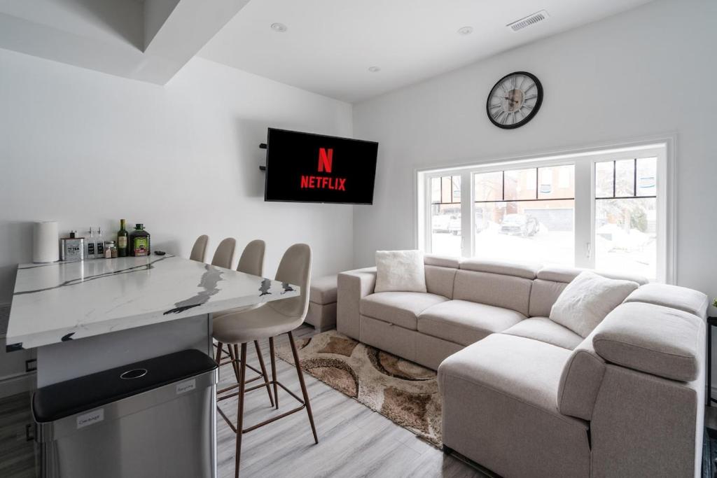 a kitchen and living room with a couch and a clock at Luxury 2 Bedroom 3 Bed Family Friendly Oasis with Smart Technology in Brampton