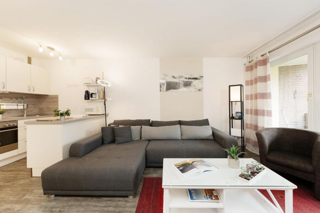 a living room with a couch and a table at Waldstraße 4 Waldkoje in Kellenhusen