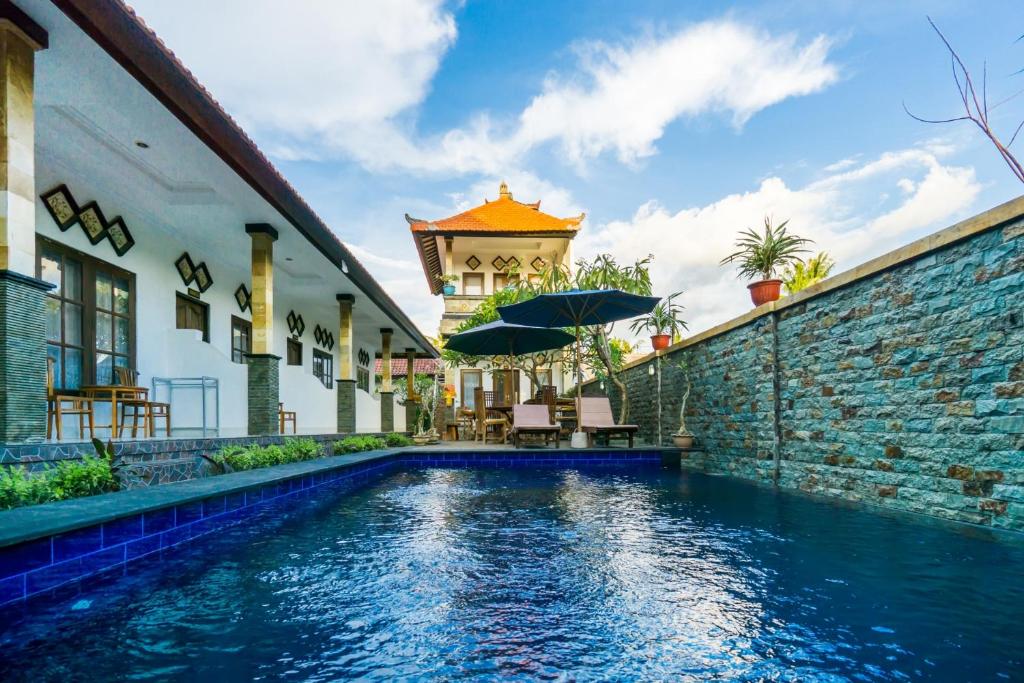 a house with a swimming pool next to a brick wall at Widia Homestay Nusa Lembongan in Nusa Lembongan