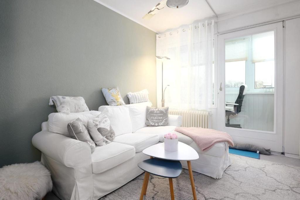 ブラズィリアンにあるMien Leevの白いソファとテーブルのあるリビングルーム