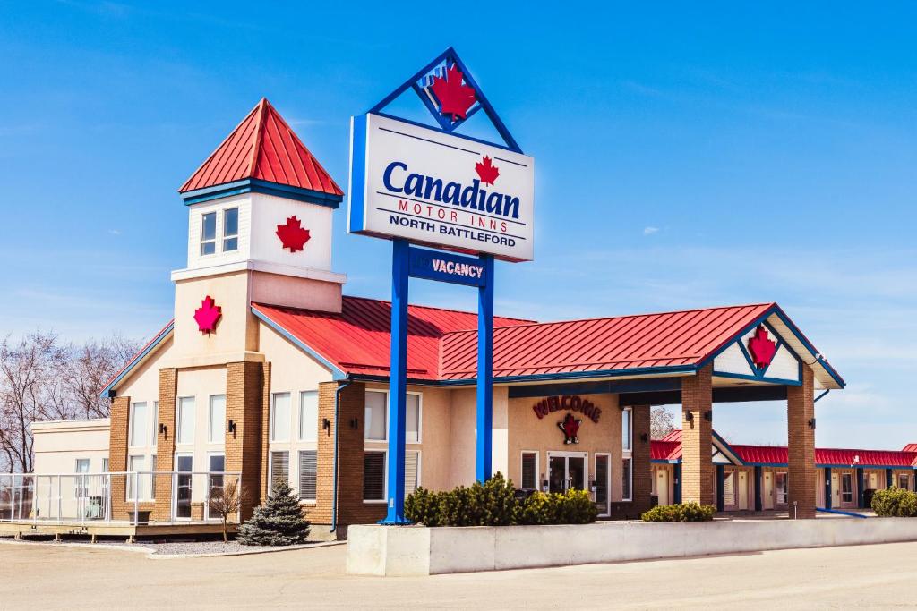 um edifício com um sinal em frente em Canadian Motel North Battleford em North Battleford