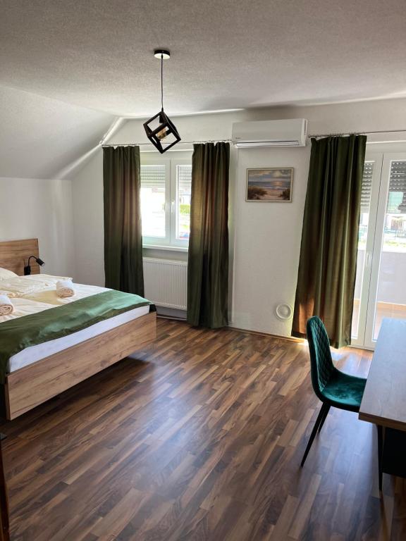 een slaapkamer met een bed, een bureau en een stoel bij Villa EXOTIC in Bihać