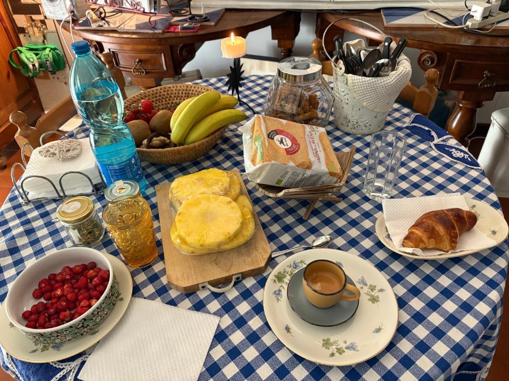 a table with a blue and white table cloth with food on it at Penelope B&B in Palermo