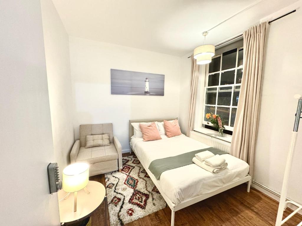 a small room with a bed and a chair at Shoreditch Rooms Near Tower Bridge in London