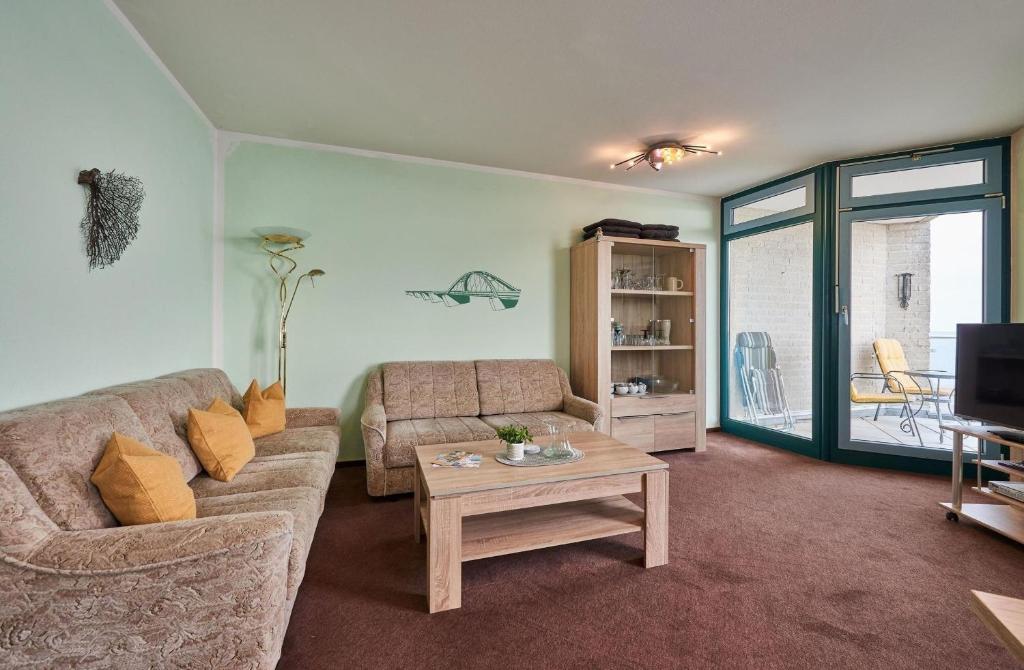 a living room with a couch and a coffee table at Am Südstrand 9 Strandburg I in Fehmarn