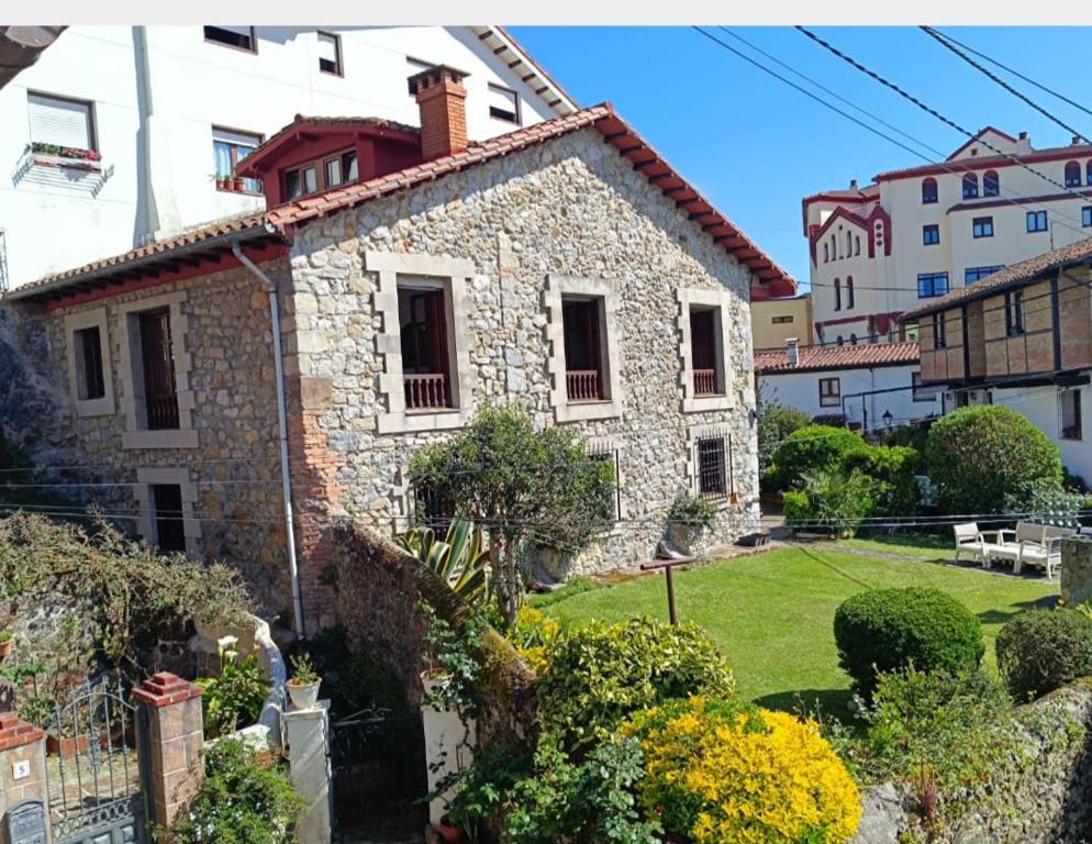 a stone house with a garden in a city at El Resbalón in Comillas