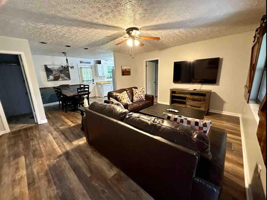 a living room with a couch and a flat screen tv at Kicback Shack - near Forge in Sevierville